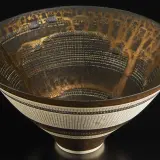 Bol en céramique aux motifs complexes, signature Lucie Rie. Le travail de la matière et les détails dorés évoquent une architecture miniature.