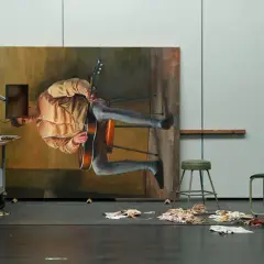 Dans l'atelier de Michael Borremans, un tableau monumental représente un homme jouant de la guitare, suspendu dans un espace onirique.