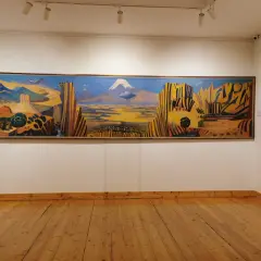 Paysage arménien aux couleurs vives, une œuvre de Martiros Saryan. Montagnes, ville et caravane de chameaux sous un ciel bleu intense.