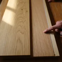 Main gauche pour reconnaître bois meuble. Deux planches de chêne sur un établi en bois, éclairées par la lumière du soleil.