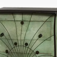 Meuble art nouveau vert texturé, orné de motifs floraux et de lignes courbes rappelant des éventails.