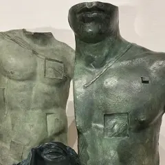 Deux torses antiques en bronze, œuvres d'Igor Mitoraj, prix de la sculpture, avec des détails gravés et une tête de femme en bas.