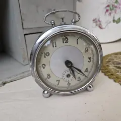 Un réveil ancien, objet de collection, prêt pour une estimation. Son cadran patiné et ses aiguilles racontent une histoire.