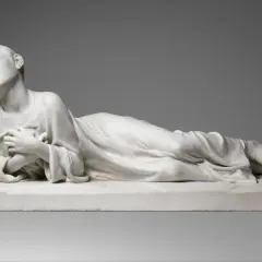 Sculpture en marbre d'une femme couchée, drapée, les yeux fermés.
