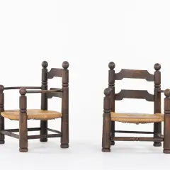 Deux fauteuils d'enfant en bois sombre, assises en paille tressée, style Charles Dudouyt.