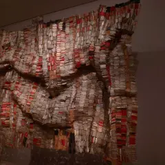 Œuvre monumentale d'El Anatsui, un rideau de bouchons de bouteilles en aluminium et cuivre, aux reflets changeants, évoquant des tissus précieux.