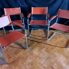 Quatre chaises modernes en cuir orange, style Matteo Grassi, sur un parquet en bois.