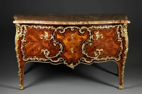 Commode Louis XV en marqueterie de bois précieux, ornée de bronzes dorés. Une estampille sur ces meubles anciens témoigne de son artisanat d'art.