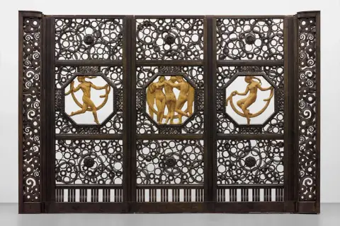 Porte monumentale en fer forgé, signature Edgar Brandt. Trois panneaux ornés de figures nues et de motifs circulaires complexes.
