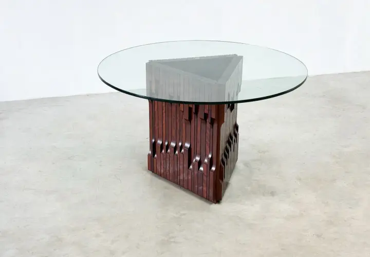 Table basse design en bois sculpté et verre, style Luciano Frigerio, avec un pied triangulaire unique.
