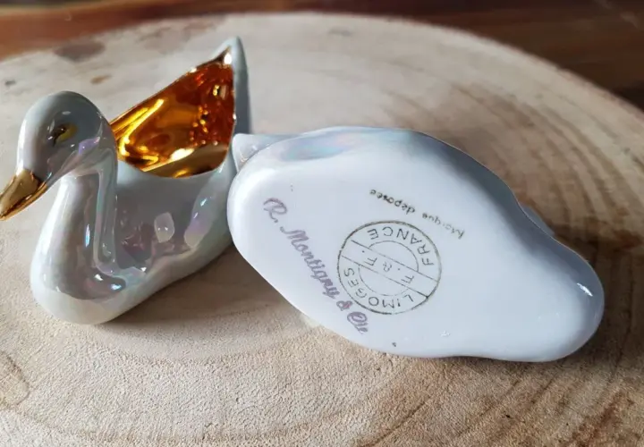 Deux cygnes en porcelaine irisée, l'un avec l'intérieur doré. L'un porte la marque pour reconnaître estampille porcelaine Limoges France.