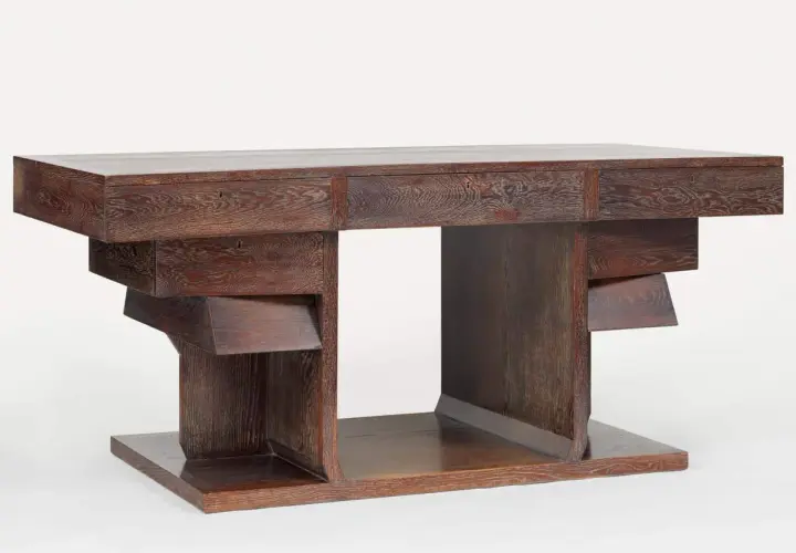 Bureau en chêne sculpté par Pierre Legrain, aux lignes géométriques audacieuses et aux tiroirs dissimulés.