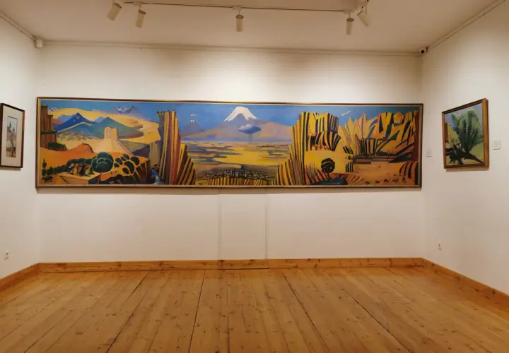Paysage arménien aux couleurs vives, une œuvre de Martiros Saryan. Montagnes, ville et caravane de chameaux sous un ciel bleu intense.