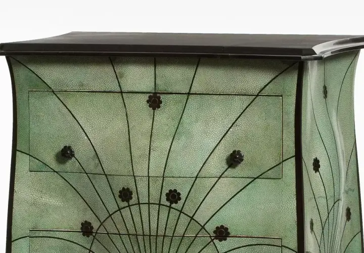 Meuble art nouveau vert texturé, orné de motifs floraux et de lignes courbes rappelant des éventails.