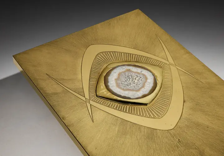Plaque en laiton brossé avec une agate polie incrustée, ornée de motifs géométriques stylisés.