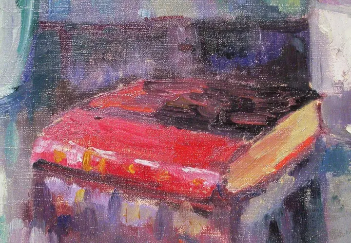 Un livre rouge vif, peut-être une œuvre de Robert Antoine Pinchon, repose sur une table, baigné de lumière.
