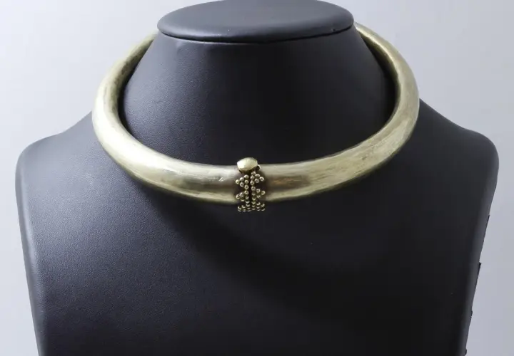 Collier rigide en laiton patiné, orné d'une grappe de perles. Un bijou d'exception, digne d'un prix Goudji.