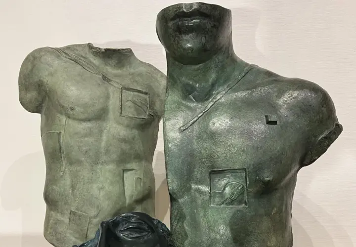 Deux torses antiques en bronze, œuvres d'Igor Mitoraj, prix de la sculpture, avec des détails gravés et une tête de femme en bas.