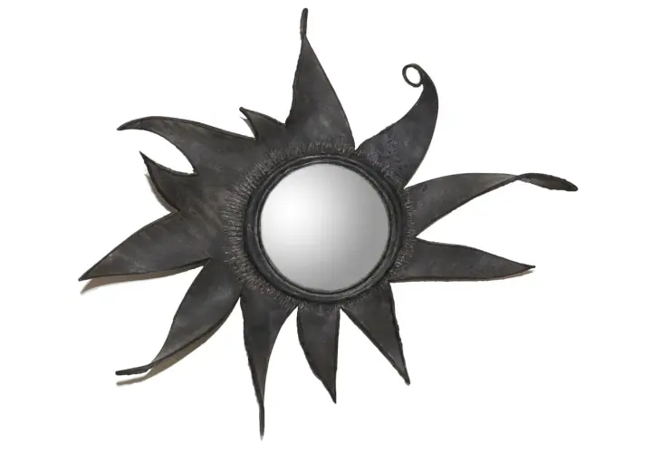 Miroir soleil en métal noir, aux rayons stylisés et pointus, rappelant l'éclat d'une étoile. Un design audacieux, digne d'une ligne Vautrin.