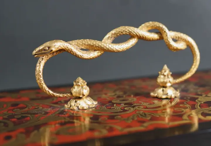 Poignée en bronze doré, un serpent enroulé, signé Susse Frères, sur un coffret orné.