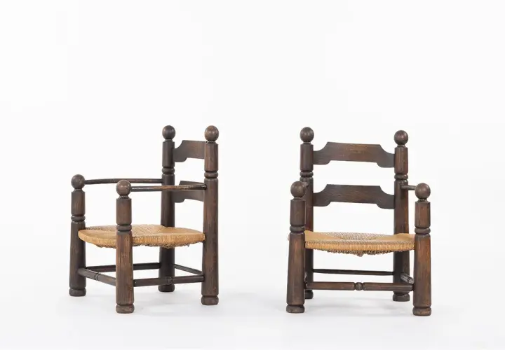Deux fauteuils d'enfant en bois sombre, assises en paille tressée, style Charles Dudouyt.