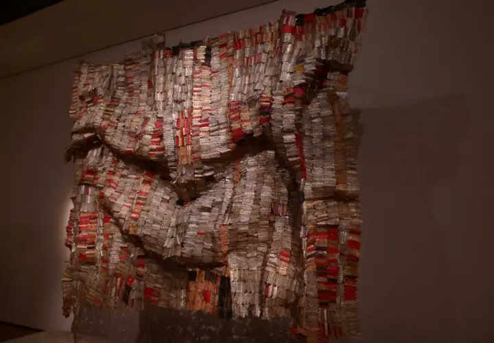 Œuvre monumentale d'El Anatsui, un rideau de bouchons de bouteilles en aluminium et cuivre, aux reflets changeants, évoquant des tissus précieux.