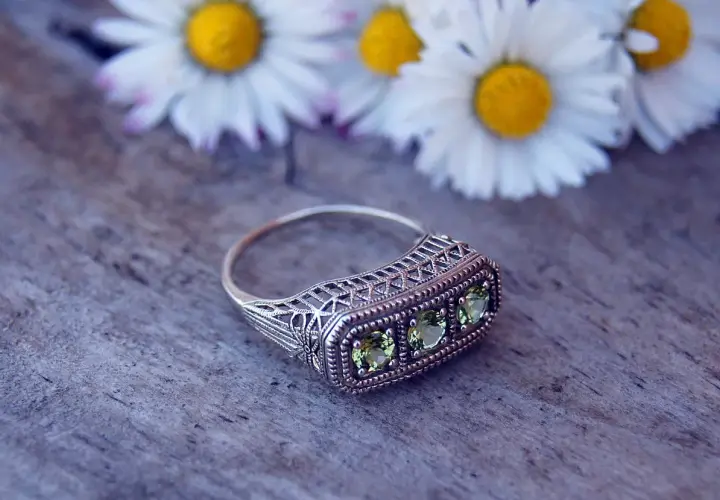 Bague ancienne en argent avec trois pierres vertes, ornée de dentelle filigrane. Une pièce parfaite pour une estimation bague ancienne.