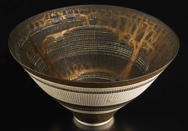 Bol en céramique aux motifs complexes, signature Lucie Rie. Le travail de la matière et les détails dorés évoquent une architecture miniature.