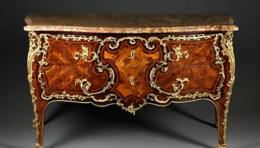 Commode Louis XV en marqueterie de bois précieux, ornée de bronzes dorés. Une estampille sur ces meubles anciens témoigne de son artisanat d'art.