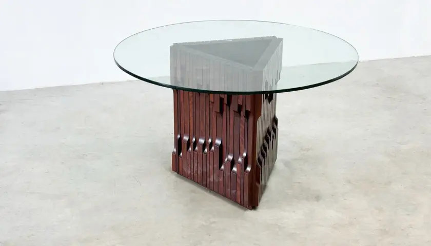 Table basse design en bois sculpté et verre, style Luciano Frigerio, avec un pied triangulaire unique.
