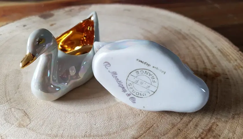 Deux cygnes en porcelaine irisée, l'un avec l'intérieur doré. L'un porte la marque pour reconnaître estampille porcelaine Limoges France.