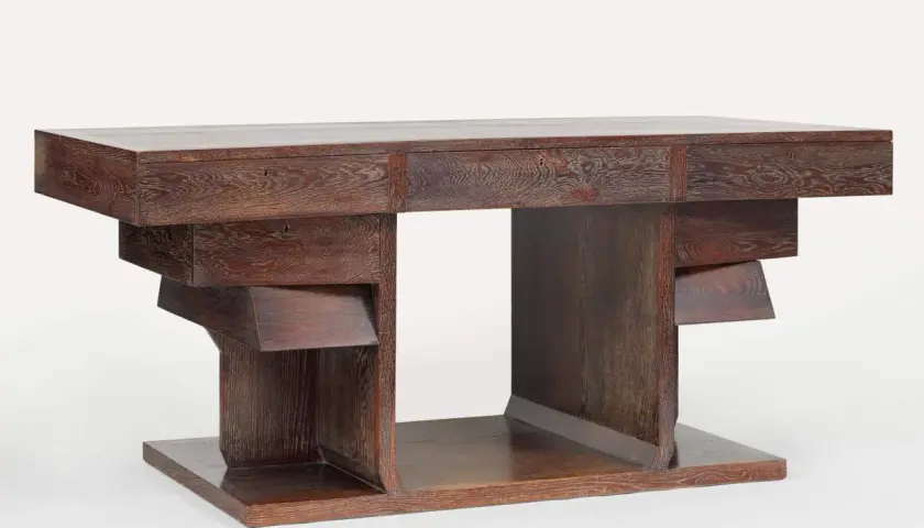 Bureau en chêne sculpté par Pierre Legrain, aux lignes géométriques audacieuses et aux tiroirs dissimulés.