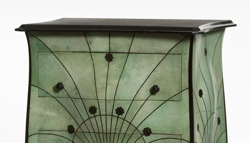 Meuble art nouveau vert texturé, orné de motifs floraux et de lignes courbes rappelant des éventails.