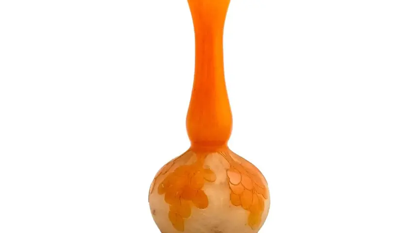 Un vase en verre orange et blanc, orné de motifs floraux délicats, un véritable verre français signature.