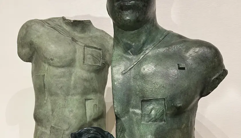 Deux torses antiques en bronze, œuvres d'Igor Mitoraj, prix de la sculpture, avec des détails gravés et une tête de femme en bas.