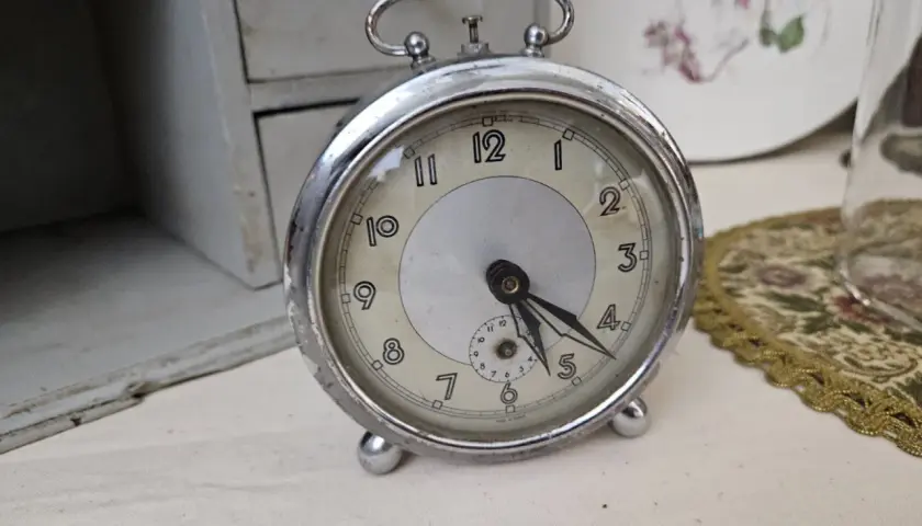 Un réveil ancien, objet de collection, prêt pour une estimation. Son cadran patiné et ses aiguilles racontent une histoire.
