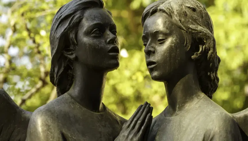 Deux anges en bronze, œuvre d'un fondeur d'art, se regardent tendrement. Leurs mains jointes évoquent une prière silencieuse.