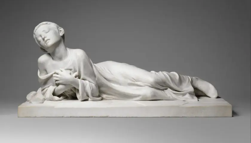 Sculpture en marbre d'une femme couchée, drapée, les yeux fermés.