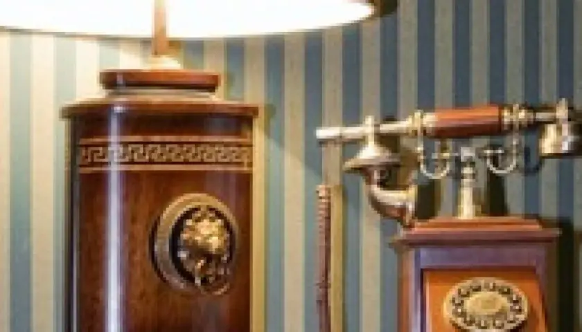 Lampe et téléphone anciens en bois, décorés de motifs grecs et de médaillons. Parfait pour une vente sur catalogue d'objets de décoration vintage.