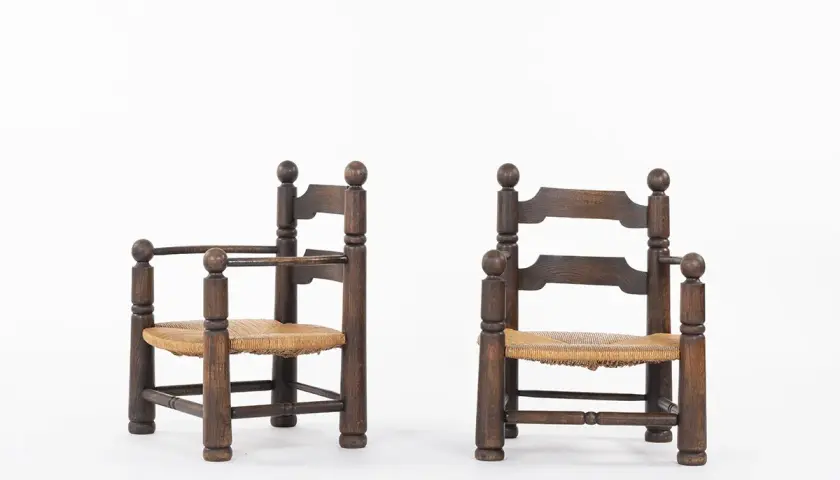Deux fauteuils d'enfant en bois sombre, assises en paille tressée, style Charles Dudouyt.
