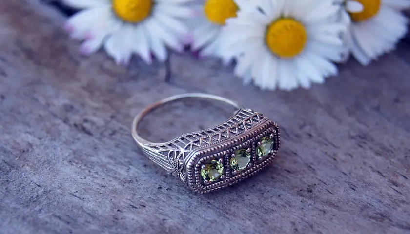 Bague ancienne en argent avec trois pierres vertes, ornée de dentelle filigrane. Une pièce parfaite pour une estimation bague ancienne.