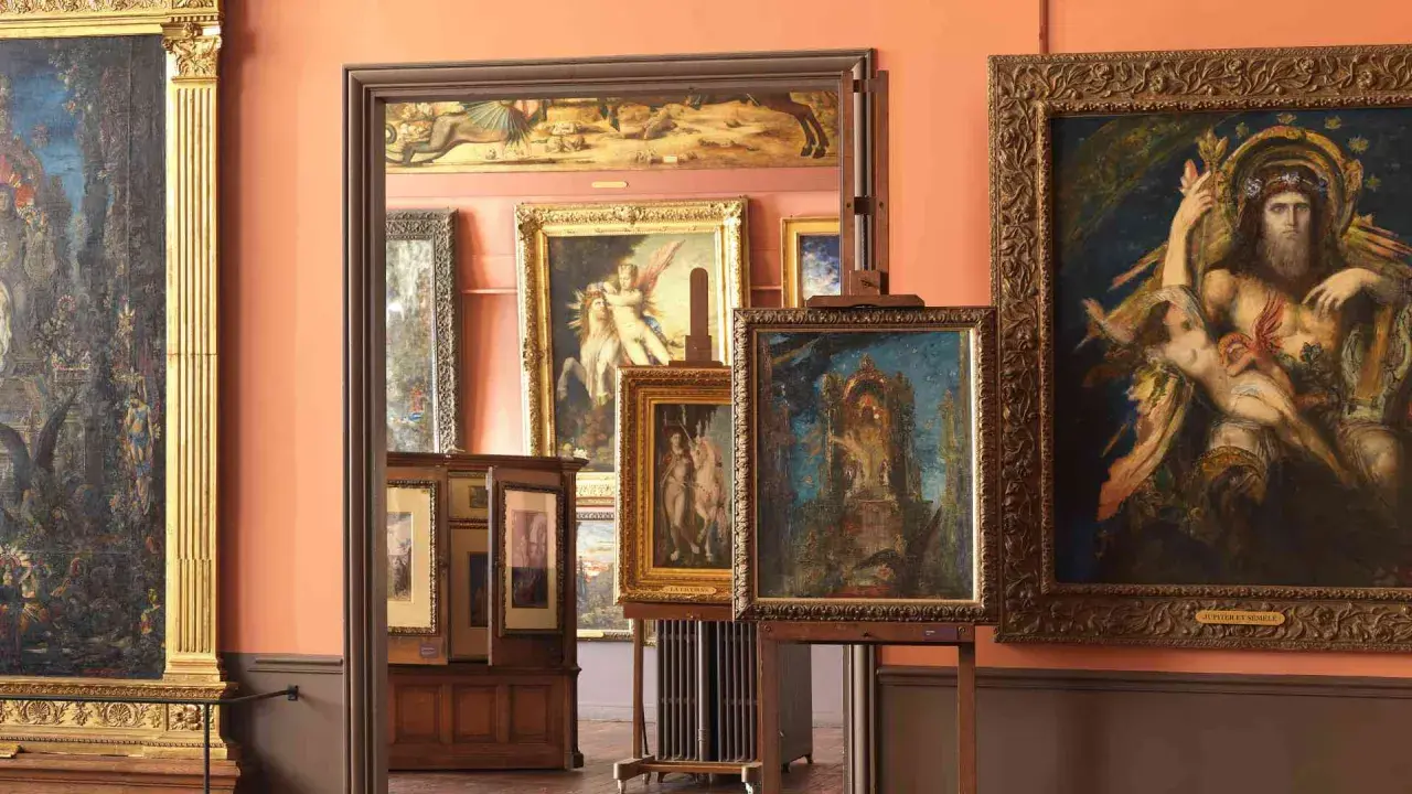 Dans un musée, des toiles de Gustave Moreau ornent les murs. On y voit des scènes mythologiques, des figures allégoriques et des paysages oniriques.