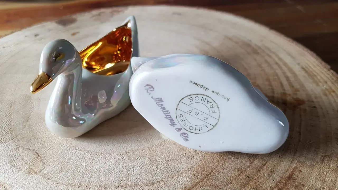 Deux cygnes en porcelaine irisée, l'un avec l'intérieur doré. L'un porte la marque pour reconnaître estampille porcelaine Limoges France.