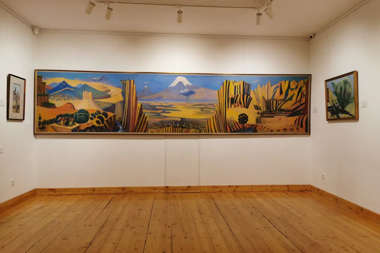 Paysage arménien aux couleurs vives, une œuvre de Martiros Saryan. Montagnes, ville et caravane de chameaux sous un ciel bleu intense.