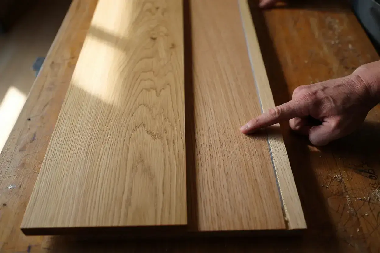 Main gauche pour reconnaître bois meuble. Deux planches de chêne sur un établi en bois, éclairées par la lumière du soleil.
