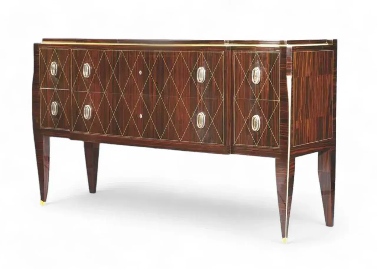 Commode Art Déco en palissandre, signée Jacques Émile Ruhlmann, avec incrustations géométriques dorées et poignées ovales.