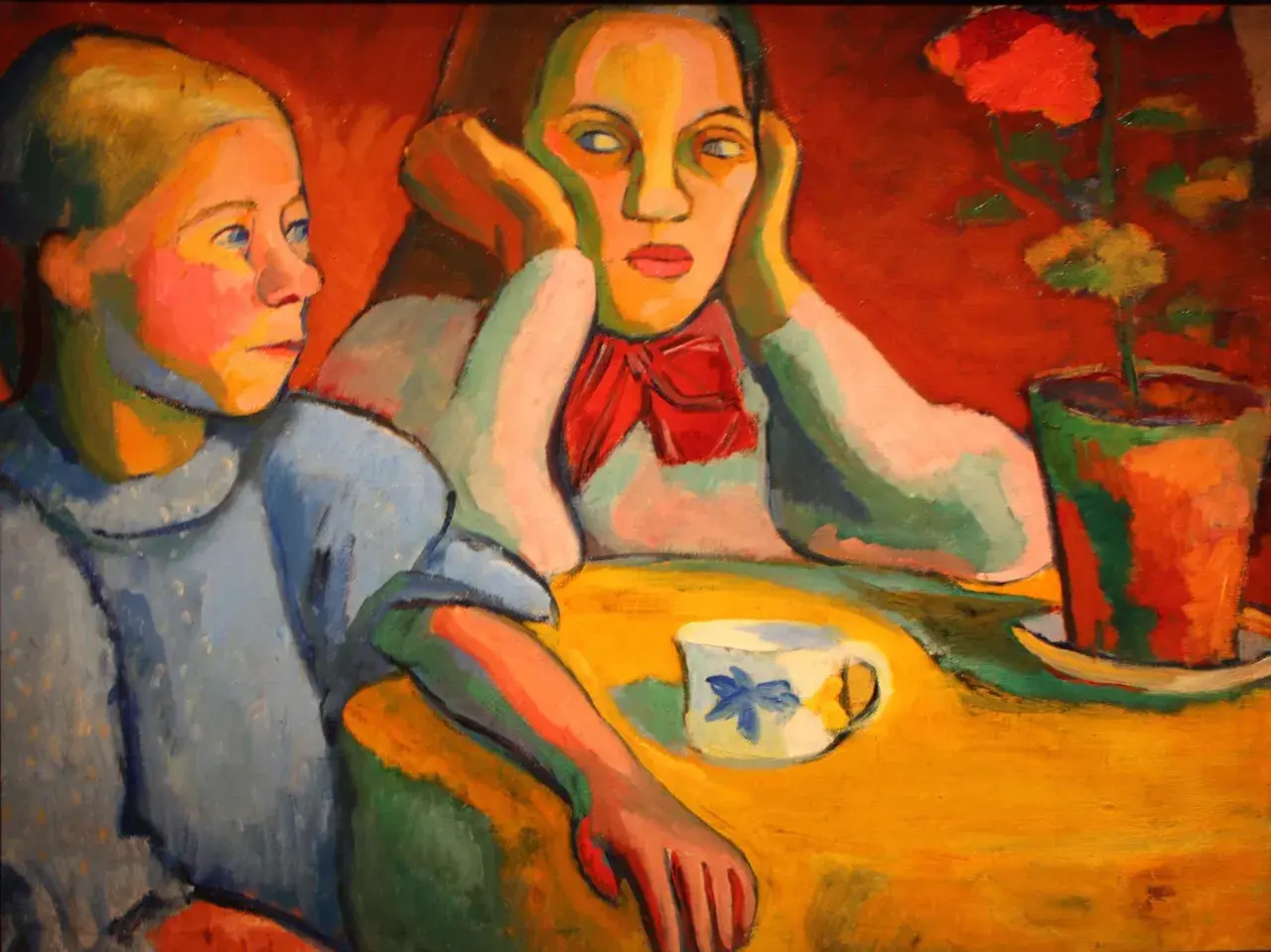 Portrait de deux jeunes femmes, peut-être Sonia et Robert Delaunay, assises à une table jaune avec une tasse et une plante.