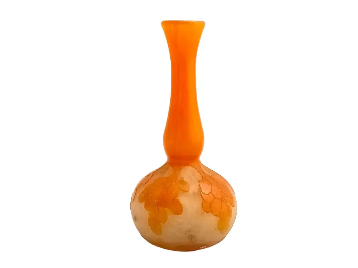 Un vase en verre orange et blanc, orné de motifs floraux délicats, un véritable verre français signature.
