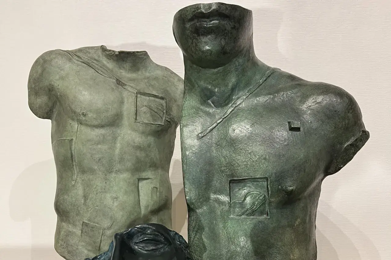 Deux torses antiques en bronze, œuvres d'Igor Mitoraj, prix de la sculpture, avec des détails gravés et une tête de femme en bas.