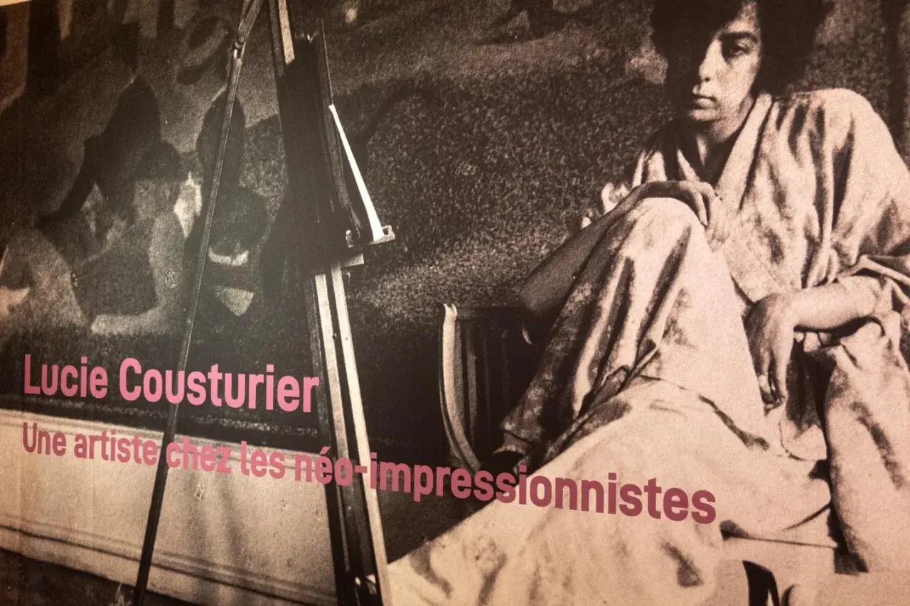 Lucie Cousturier, une artiste chez les néo-impressionnistes. Portrait d'une femme assise, vêtue d'une robe ample, devant un chevalet.
